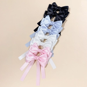Set mit vier Schleifen-Haarspangen aus Satin in Schwarz, Hellblau, Weiß und Rosa