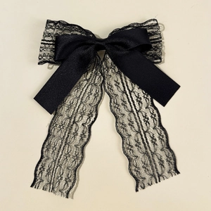 Detailed view of elegant double-layered black satin ribbon and floral lace bow hair clip