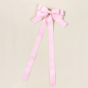 Elegant pink satin bow hair clip with long ribbons for women, minimalist aesthetic style