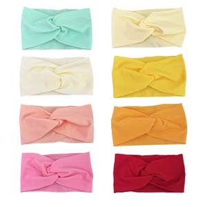 Detailed set of eight colorful twisted knot knit baby headbands in elastic fabric