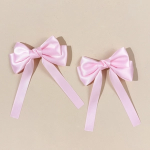 Detailansicht der rosa Satin-Haarschleifen mit langen Bändern und glatter Seide