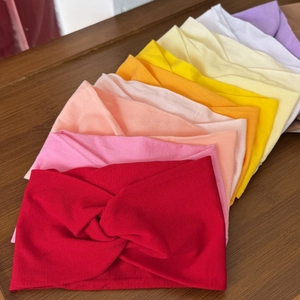 Close-up of multicolored elastic baby headbands with knot detail on wood background