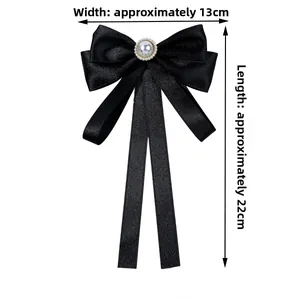 Detail van elegante zwarte satijnen strik met parel, afmeting 13 cm breed en 22 cm lang