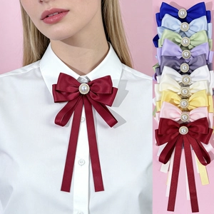Detail of satin bow brooch with pearl center available in multiple vibrant colors