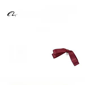 Detailed view of burgundy satin bow tie with elegant pearl pendant for uniform accessory