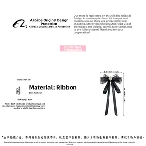 Detail view of black lace bow hair clip with rhinestones and pearls measuring 14.5x27cm