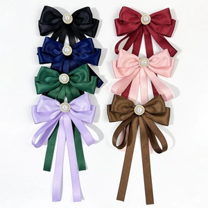 Detail of silk satin bow clips with pearl center in seven different elegant colors
