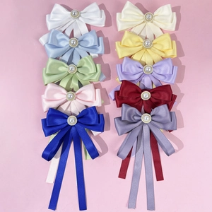 Detail of colorful satin bow tie set with central pearl and rhinestone embellishments