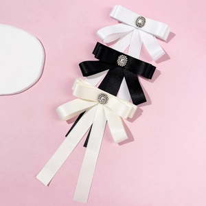 Three-piece set of satin bow tie brooches in black white and cream with crystals