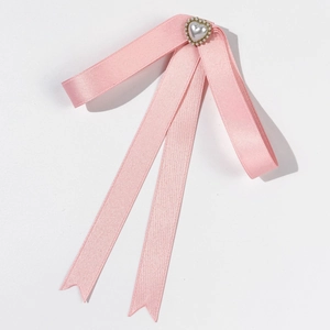 Broche nœud en satin rose avec perle en cœur et longs glands en soie sur blanc