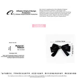 Detail view of pre-tied black ribbon bow tie with heart jewel and dimensions 14x8cm