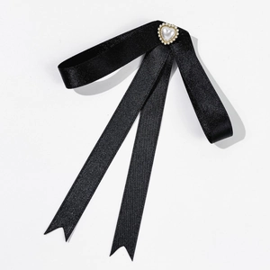 Détail d'un nœud papillon en satin noir avec un élégant pendentif cœur en perles
