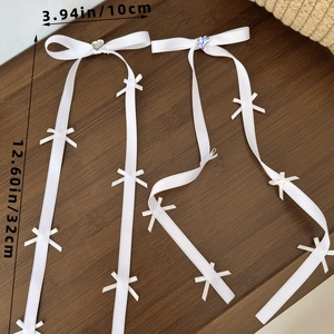 Dettaglio del fiocco in seta bianca con strass a cuore e nastri lunghi 32 cm di lunghezza