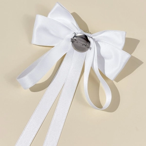 Detail of the multi-layer white satin bow brooch with long ribbons and metal safety pin