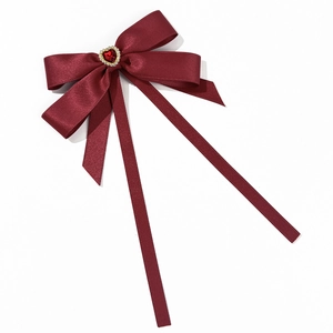 Nœud élégant en satin bordeaux avec une pierre en forme de cœur et rubans fluides