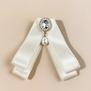 Elegant ivory satin bow brooch with sparkling rhinestones and drop pearl pendant