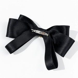Detailed back view of a black satin bow tie with a silver metal safety pin fastener