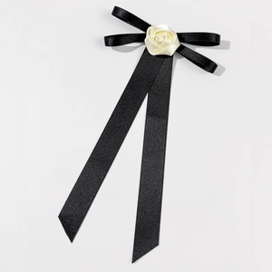 Elegant black ribbon bow brooch with a delicate cream white fabric rose center detail