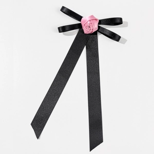 Detail of a vintage black silk bow brooch featuring a central pink satin handmade rose