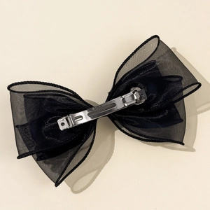 Detail of the silver metal spring clip with CLIP PARIS engraving on black mesh bow