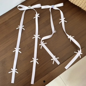 Dettaglio di fermagli per capelli in raso bianco con strass colorati a forma di cuore