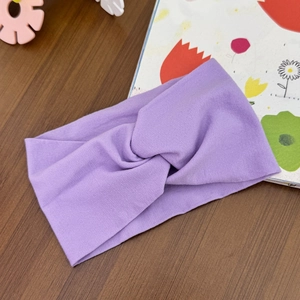 Detail view of lavender purple cross-knot baby headband in soft elastic knit fabric