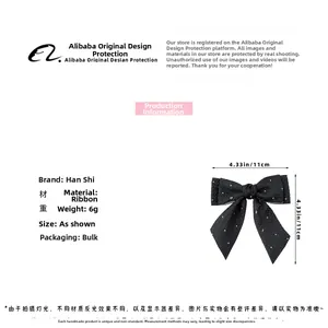 Détail d'un nœud papillon à pois noirs de 11cm en tissu léger de 6g pour cheveux de fille