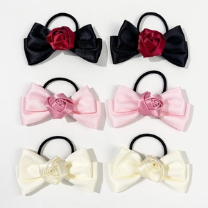 Lot de 6 chouchous en satin avec roses et nœuds en noir, rose et blanc sur fond blanc uni