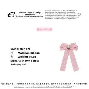 Detailed view of pink plaid ribbon bow hair clip with white pearls and gold bead charm