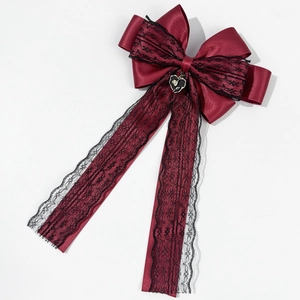 Détail du nœud en satin bordeaux avec dentelle noire et pendentif cœur de rose