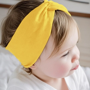 Elastic baby headband in bright ginger yellow with stylish wide twisted knot design