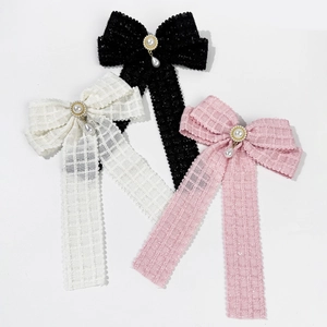 Set of three elegant plaid bow hair clips with pearls in black, white, and pink tones