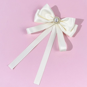 Elegant white silk bow brooch with a large central pearl and long ribbon tassels