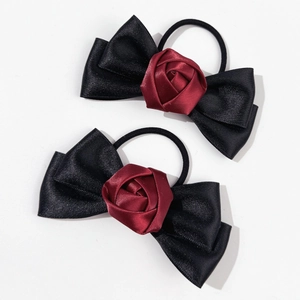 Détail des chouchous avec nœud en satin noir et rose rouge sur élastiques souples