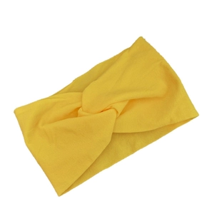 Elastic bright yellow twisted headband for babies made of soft knit cotton fabric