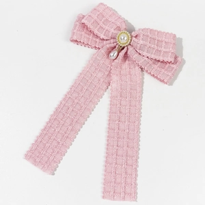Detailed texture of pink tweed bow hair clip with faux pearl and water drop pendant