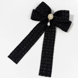 Detail of tweed bow hair clip with faux pearl center and dangling drop pearl charm