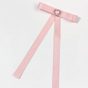Dettaglio del fiocco in raso rosa con decorazione a cuore in strass scintillanti