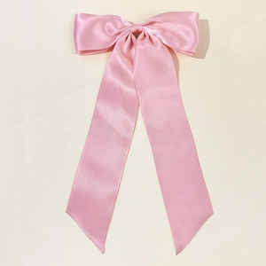 Dettaglio del fiocco in raso rosa liscio con eleganti nastri lunghi