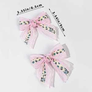 Dettaglio di fermagli per capelli in pizzo rosa da 8,5 cm con motivi floreali e fiocco