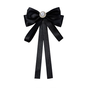 Elegant black silk satin bow tie brooch with a large pearl center and long ribbon tails