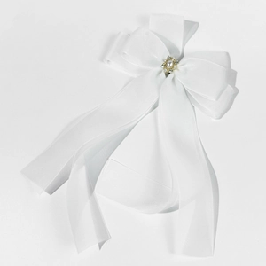 Détail d'une barrette nœud en résille blanche avec perle centrale et strass brillants