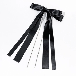 Détail de la barrette nœud en satin noir avec de longs pompons en strass argentés