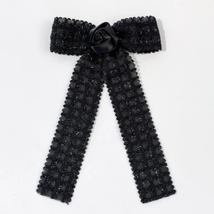 Detail of black lace bow hair clip featuring a handmade satin rose and glittery mesh fabric