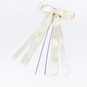 Détail du nœud papillon en satin avec glands en strass et longs rubans de couleur ivoire