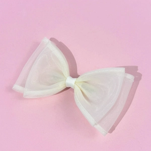 Close-up of white mesh bow hair clip featuring double-layered translucent fabric texture