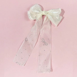 Détail du nœud papillon en tulle blanc avec strass argentés brillants et longs rubans élégants