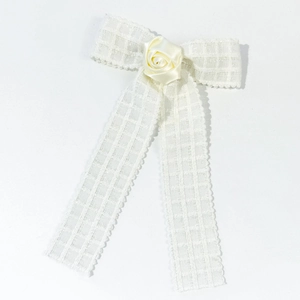Close-up of cream white lace bow hair clip featuring a delicate satin rose center decoration
