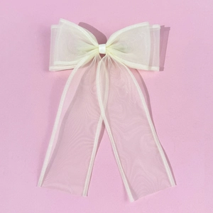 Creamy white multilayer organza bow hair clip with long tassels on pink background
