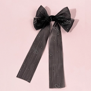 Détail d'un nœud à cheveux élégant en tulle noir avec strass brillants sur voile fin